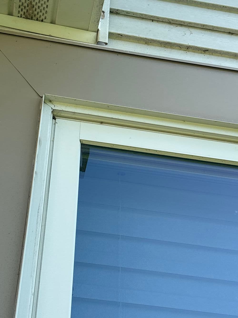 Close-up of a window corner showing clean glass and a light-colored frame.