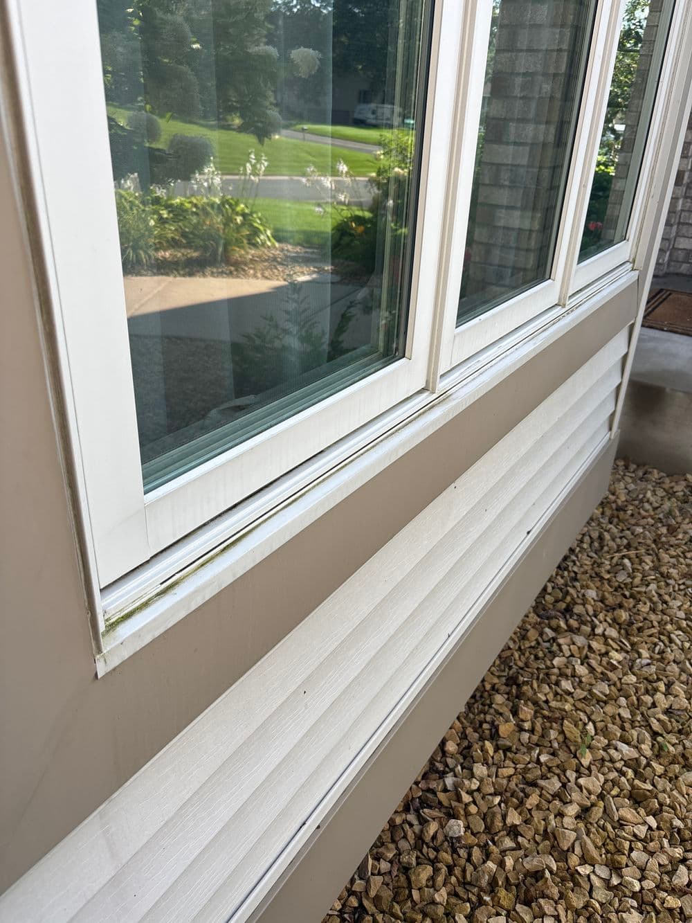 Close-up of a house window with clean frames and exposed siding, highlighting exterior details.